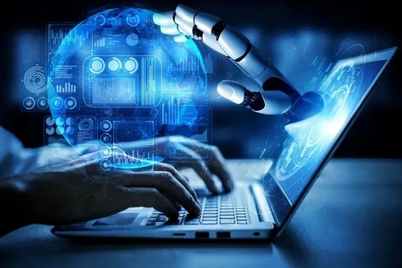 Robot hand and human hands interacting with a laptop, symbolizing AI and technology integration.